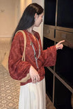 Woman in a red patterned blouse and white skirt pointing at a display cabinet.