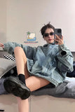 Person wearing a denim outfit sitting on a couch with a brand logo in the corner.