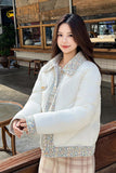 Woman wearing a white puffer jacket with floral patterns in an outdoor setting