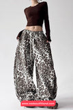 Person wearing leopard print pants and a brown top on a white background with 'nadaoutfitland.com' branding.