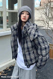 Person wearing a plaid jacket and gray beanie outdoors
