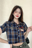 Person wearing a plaid shirt with a neutral background