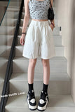 Person wearing a gray tank top with black polka dots, white shorts, and black and white sneakers on a staircase.
