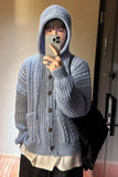 Person wearing a blue knitted cardigan taking a mirror selfie.