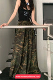 Person wearing a black tank top with a number 2 design and camouflage pants, standing on a staircase.