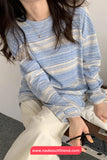 Person wearing a blue and white striped sweater with a plain background