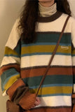 Person wearing a colorful striped sweater with a plain background