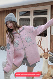 Woman in a pink knitted cardigan with animal patterns standing in a snowy landscape with a deer.