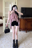 Person taking a mirror selfie wearing a pink top, black shorts, and black boots in a room.