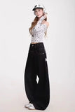 Person wearing a white polka dot top and black high-waisted jeans on a white background