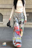 Person wearing a colorful denim skirt with cat designs in front of a stone building.