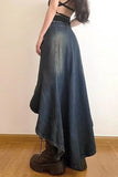Person wearing a long denim skirt with a plain background
