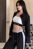 Person wearing a black shirt with 'alexanderwang' branding and white pants.