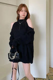 Woman wearing a black outfit with a matching handbag indoors.