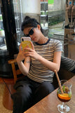 Woman taking a selfie in a cafe with a drink on the table