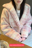 Person wearing a pink and white checkered robe with a blurred background