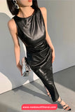 Person wearing a black leather outfit with a plain background
