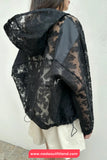 Person wearing a black lace hooded jacket with a white background