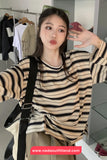 Person wearing a striped shirt in a clothing store with a visible brand watermark.