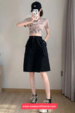 Person wearing a black skirt and crop top in a room with a neutral background