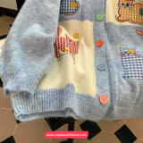 Children's cardigan with cat patterns and buttons on a checkered background