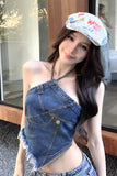 Woman wearing a denim top and shorts with a colorful cap indoors.