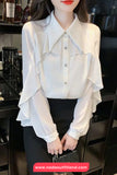 White ruffled blouse worn by a person in an indoor setting