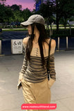 Woman wearing a striped top and beige cap in an outdoor setting